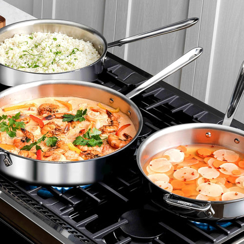 Two All-Clad D3 Stainless Sauté Pans on a gas stovetop, one with rice and one with a tomato shrimp dish