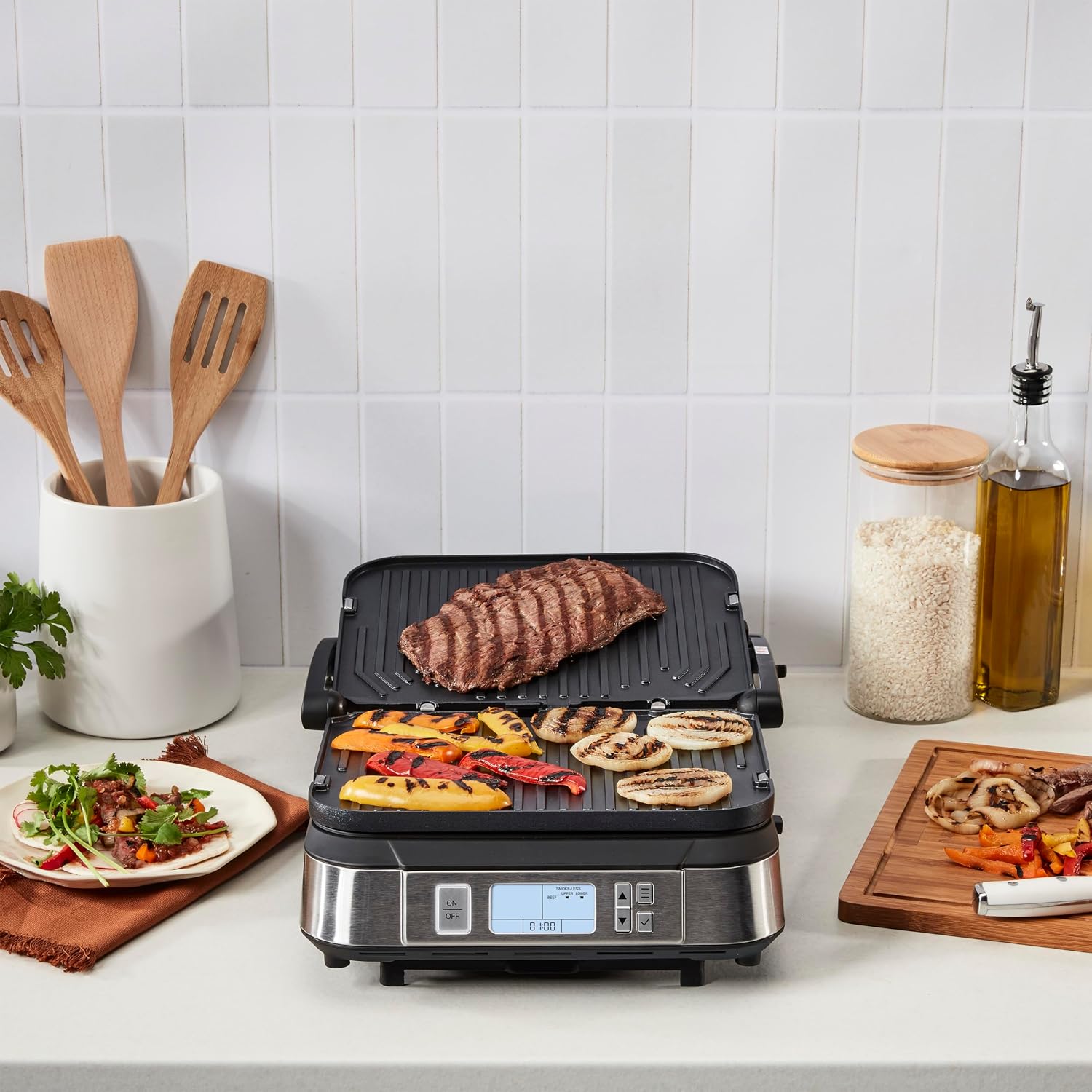 Cuisinart Griddler open on a kitchen counter grilling steak, peppers, and onions