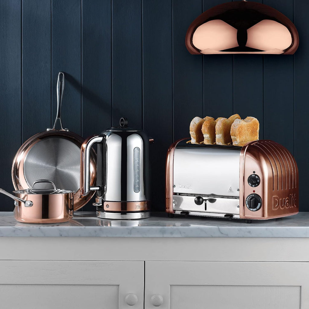 Dualit Classic 4-Slice Toaster in copper, shown on a kitchen counter with a matching kettle and cookware