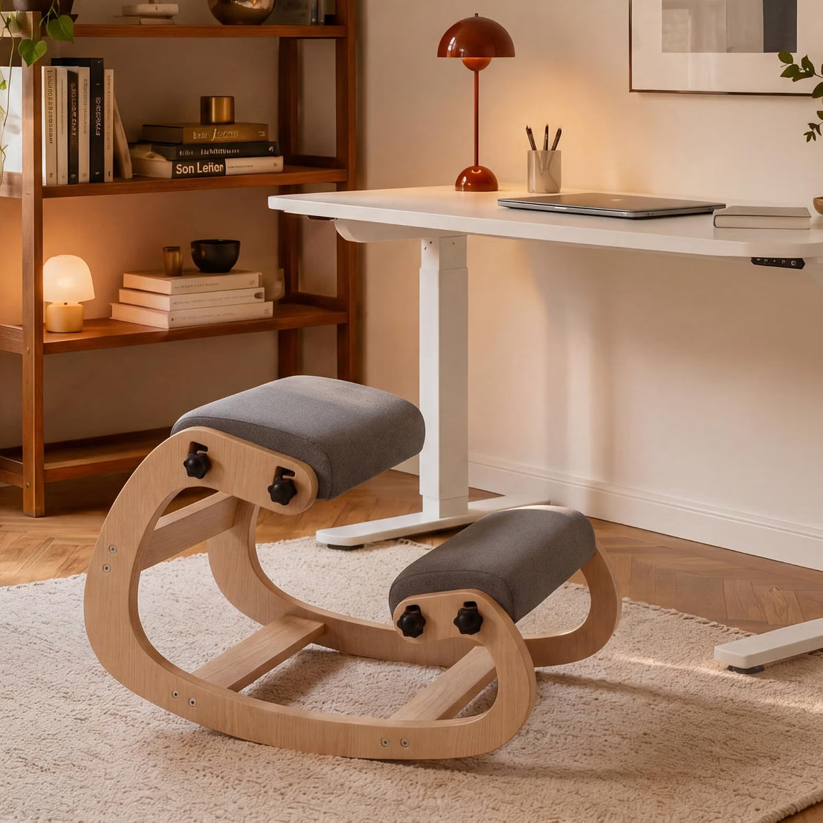 Wooden ergonomic kneeling chair beside a standing desk in a warm home office