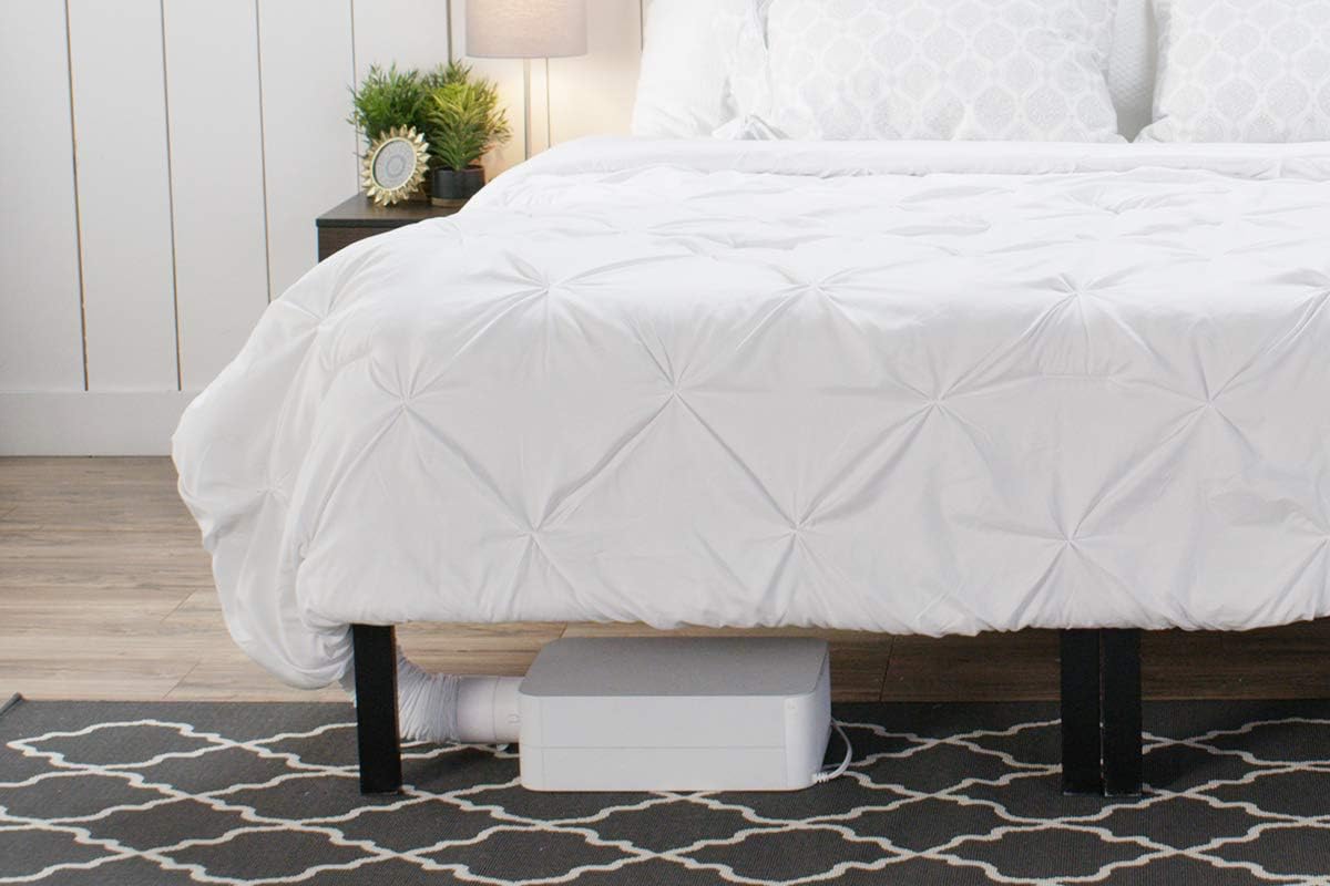 BedJet unit tucked under a bed with a white comforter and patterned rug
