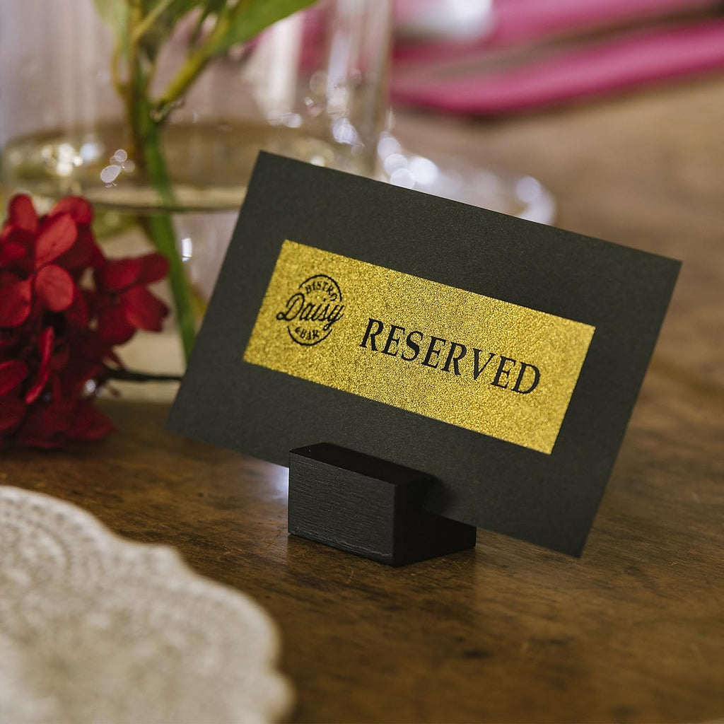 Brother P-touch CUBE Plus Label Maker with a printed Reserved label on a table place card holder