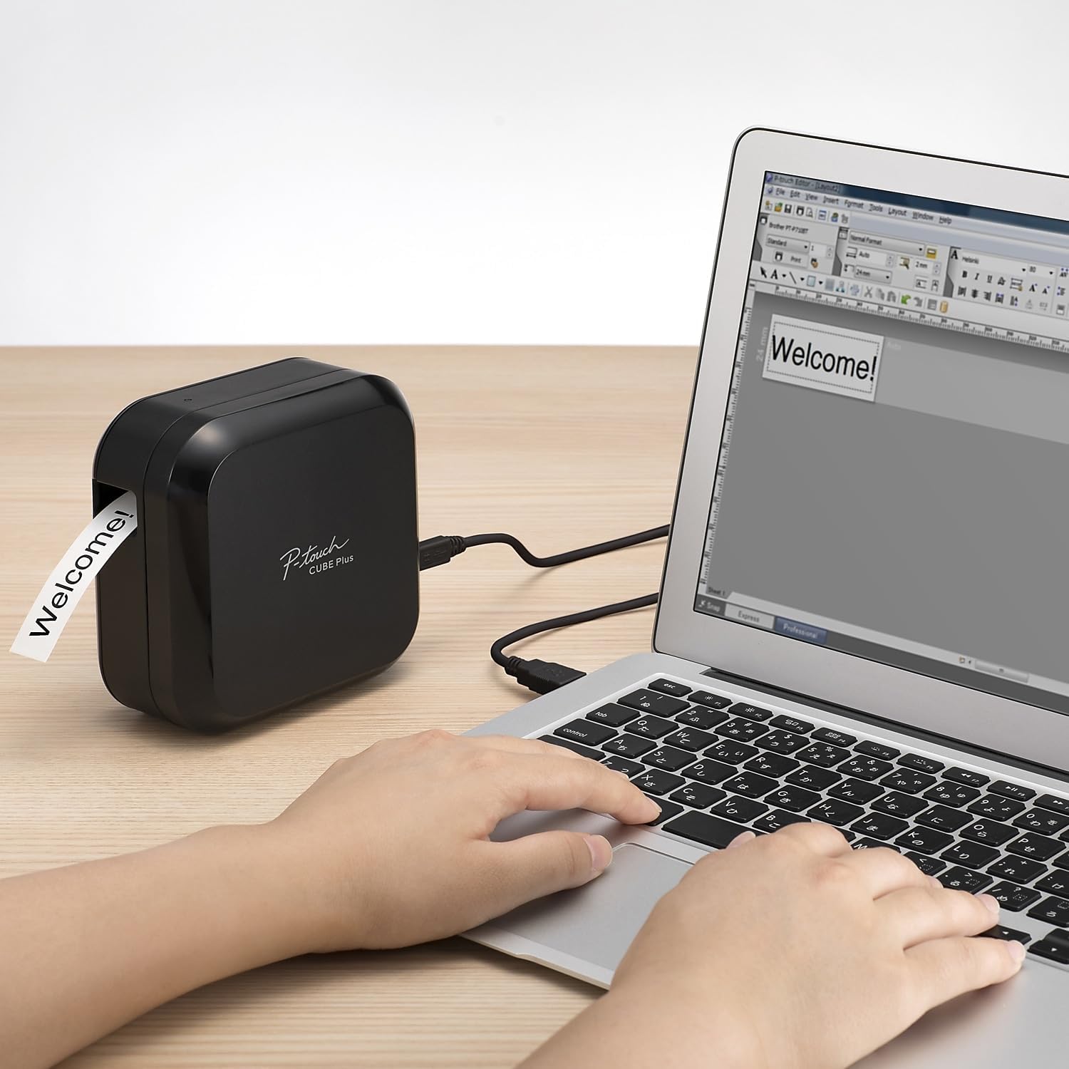 Brother P-touch CUBE Plus Label Maker on a desk next to a laptop