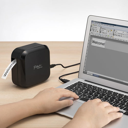 Brother P-touch CUBE Plus Label Maker on a desk next to a laptop