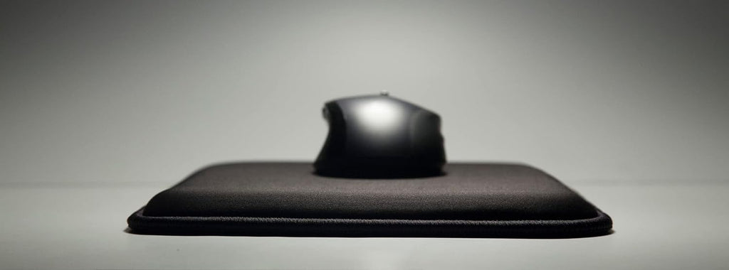 Close-up side profile of the black Loftmat cushioned mouse pad with a mouse resting on top