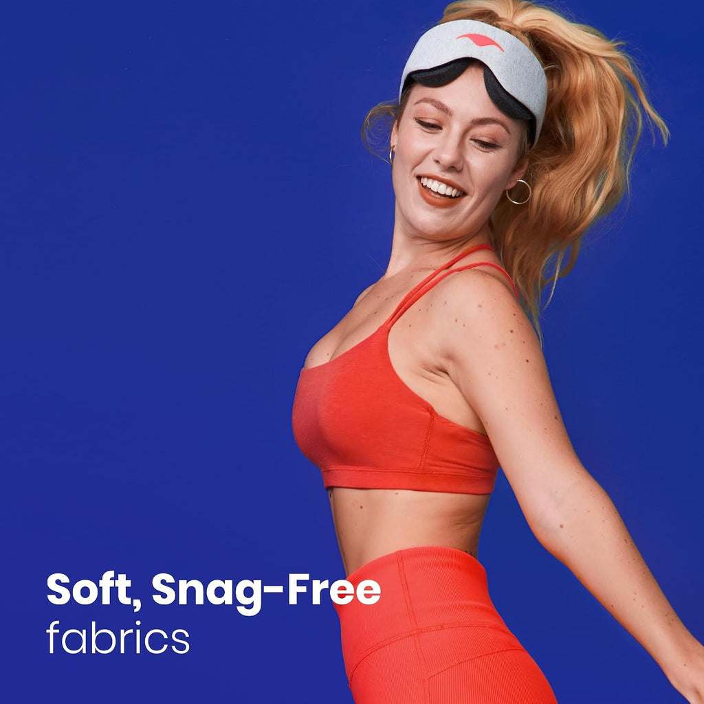 Woman wearing the Manta Sleep Mask pushed up on her forehead while stretching, graphic reading Soft, Snag-Free fabrics